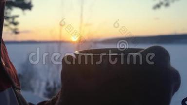 日落时分，这个旅游女孩正在雪白的冬林里用<strong>保温</strong>瓶喝茶